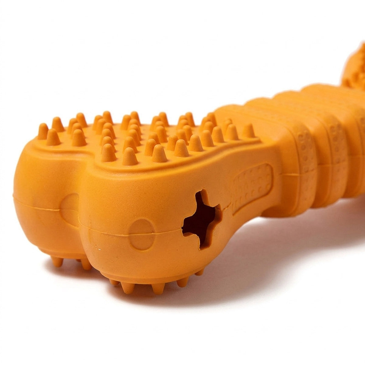 Close-up of the cross shaped treat opening and rubber nubs on the orange chew bone