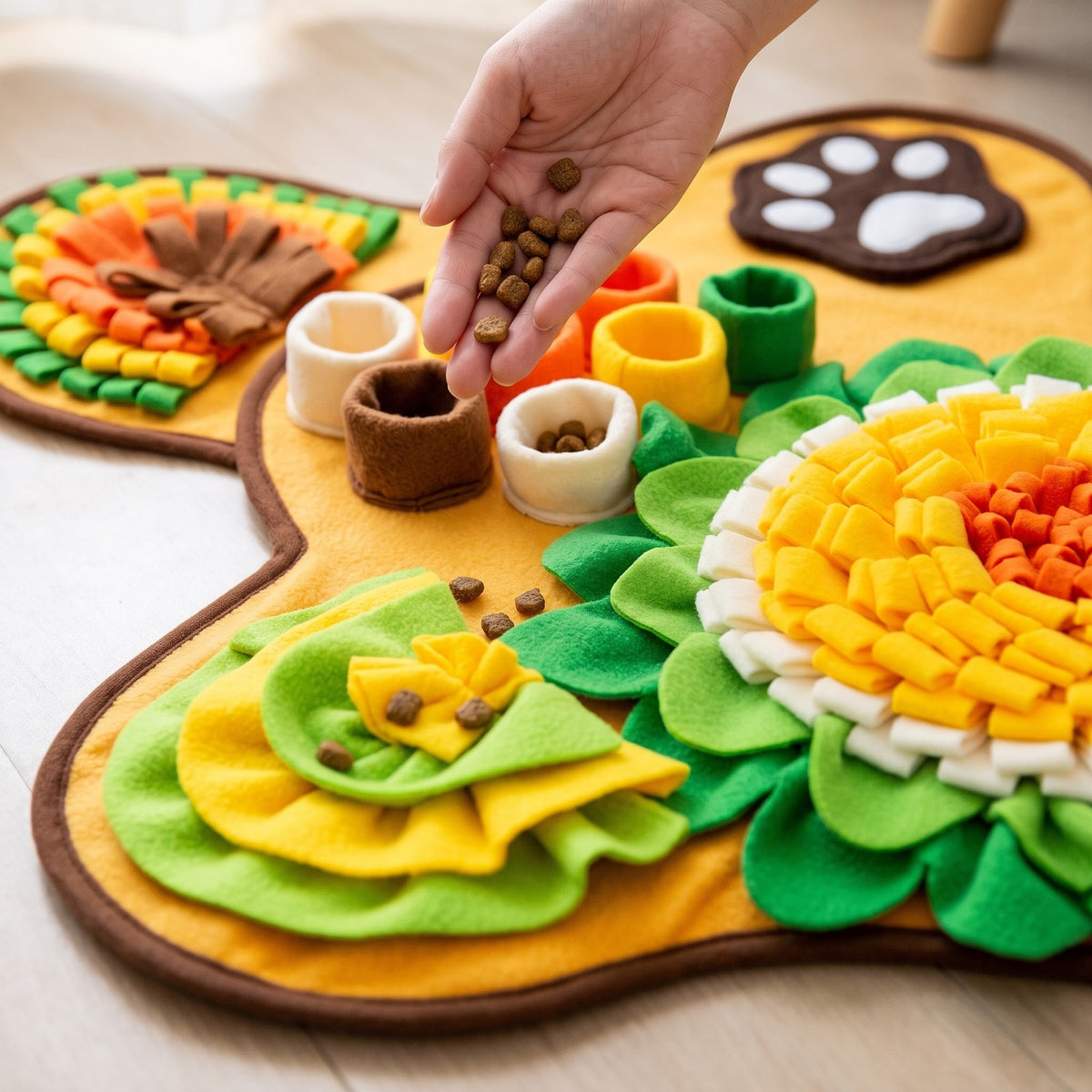 Hand dropping kibble into the fleece treat cups of the bone snuffle mat