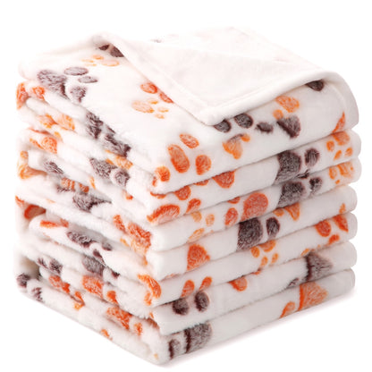 Cream fleece dog blanket with orange and brown paw prints