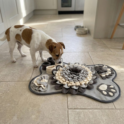 Jack Russell Terrier sniffing a grey bone snuffle mat on a kitchen floor